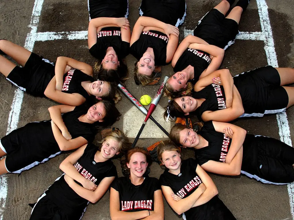 Softball team photo of players surrounding home plate